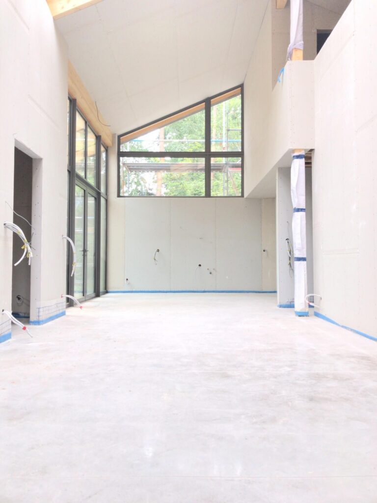Interieur in opbouw met hoge ramen &mdash; woning Collier, Keerbergen