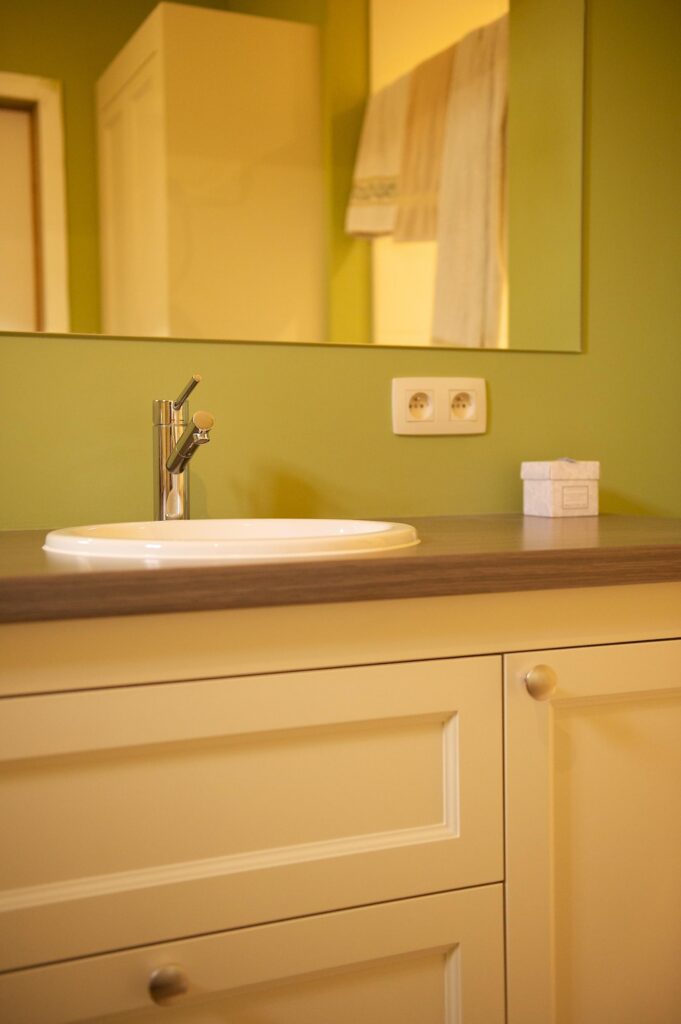 Badkamer detail met geel kleuraccent &mdash; woning Klein-Spillemaeckers, Haacht