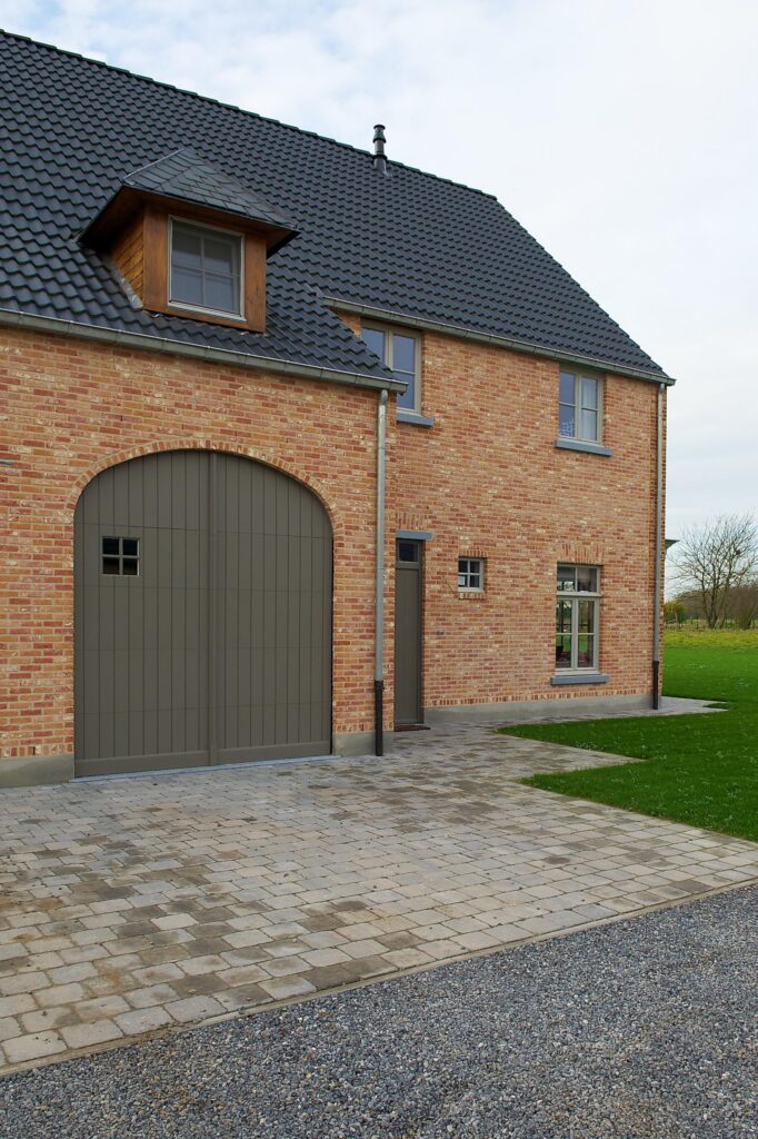 Exterieur bakstenen woning met garagedeur &mdash; woning Klein-Spillemaeckers, Haacht