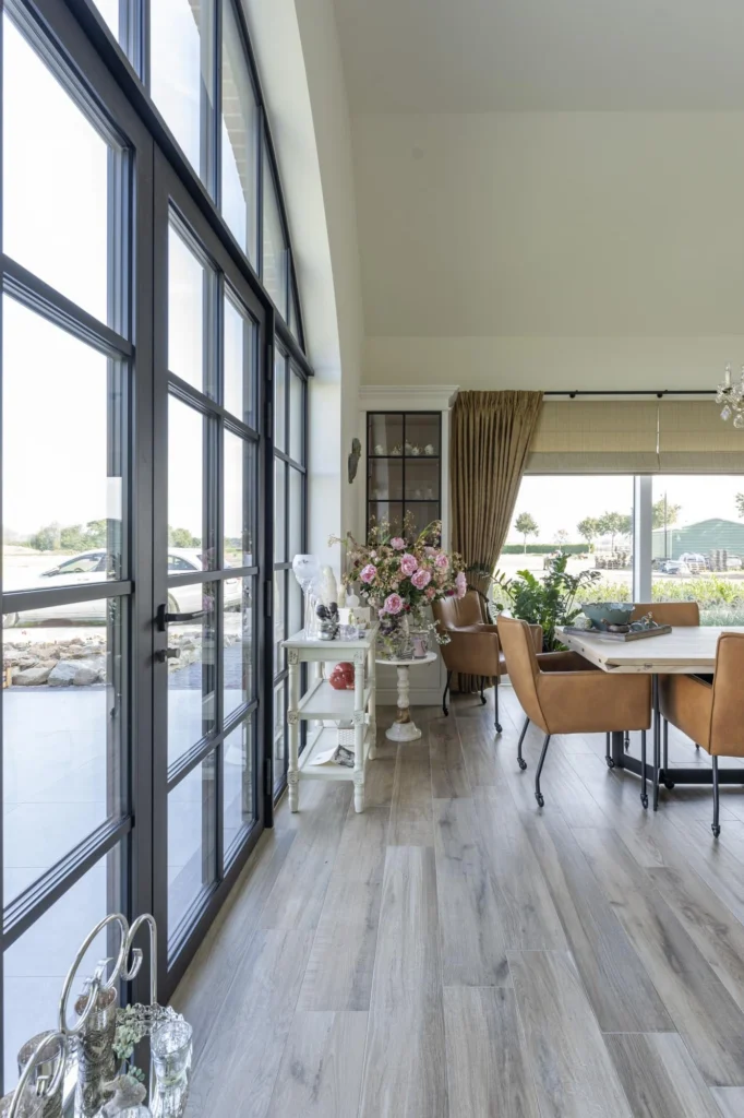 Leefruimte met haard en grote ramen &mdash; woning Maris, Ravels