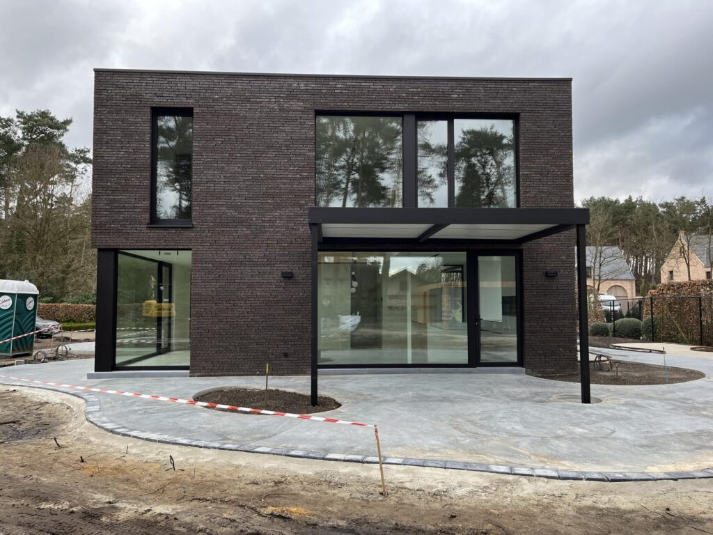 Exterieur donkere bakstenen woning met houten carport &mdash; woning Dierckx, Mol