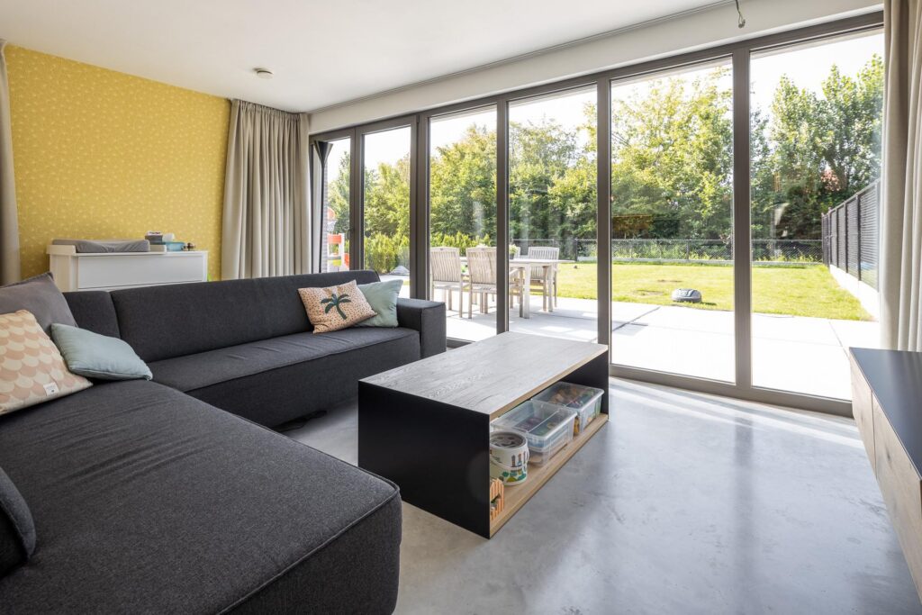 Leefruimte met grote ramen en tuin &mdash; woning De Buyser, Willebroek